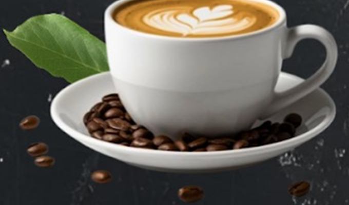 Cappuccino with latte art on a saucer with coffee beans
